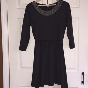 Short black dress with jewel around the neckline.